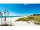 Expansive beach view with white sand, blue sky, and calm turquoise water at 791 Saint Judes Dr N, Longboat Key, FL 34228