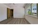 Bright bedroom with wood-look tile, ceiling fan, and window overlooking a tropical view at 791 Saint Judes Dr N, Longboat Key, FL 34228