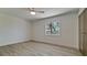 Bright bedroom with wood-look tile, ceiling fan, and window overlooking a tropical view at 791 Saint Judes Dr N, Longboat Key, FL 34228