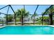 Waterfront view of screened pool with lush tropical landscaping at 791 Saint Judes Dr N, Longboat Key, FL 34228