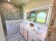 Luxurious bathroom with a frameless glass shower, double sinks, and tranquil views at 834 Springwood Cir, Bradenton, FL 34212