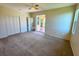 Spacious bedroom with neutral carpet, ceiling fan, and a sliding glass door to the lanai at 834 Springwood Cir, Bradenton, FL 34212