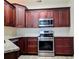 Modern kitchen with stainless steel oven, granite countertops, and dark wood cabinets, adding a luxurious feel at 834 Springwood Cir, Bradenton, FL 34212