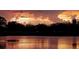 Sunset landscape with the tree silhouettes in the distance reflected in the lake water at 834 Springwood Cir, Bradenton, FL 34212