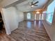 Open living room features wood-look flooring, ceiling fan, neutral paint, and abundant natural light at 834 Springwood Cir, Bradenton, FL 34212