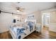 Beautiful bedroom with sliding barn door to bath, offering a ceiling fan and coastal decor at 842 Jolanda Cir, Venice, FL 34285