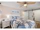 Stylish bedroom featuring a decorative bedspread, ceiling fan, and sliding barn door leading to laundry at 842 Jolanda Cir, Venice, FL 34285
