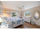 Cozy bedroom with ceiling fan, wood floors, and white furnishings for a bright coastal feel at 842 Jolanda Cir, Venice, FL 34285