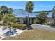Exterior view of the clubhouse featuring a blue roof, stone accents, and palm tree landscaping at 842 Jolanda Cir, Venice, FL 34285