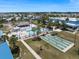 Aerial view of the community pool and recreational area with shuffleboard courts and tiki bar at 842 Jolanda Cir, Venice, FL 34285