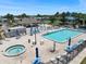 Overhead angle of the community pool, tiki bar and lounge with a luxurious hot tub and plenty of seating at 842 Jolanda Cir, Venice, FL 34285