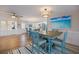 Dining room features a wood table with blue chairs and beach artwork at 842 Jolanda Cir, Venice, FL 34285