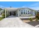 Charming single-story home with a light-blue exterior, landscaped flower beds, and a spacious carport at 842 Jolanda Cir, Venice, FL 34285