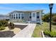 Charming single-story home with a light-blue exterior, landscaped flower beds, and a well-lit walkway at 842 Jolanda Cir, Venice, FL 34285