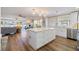 Open-concept kitchen with white cabinets, stainless steel appliances, wood-look floors, and a large center island at 842 Jolanda Cir, Venice, FL 34285