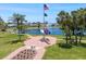 Scenic view of a lake with a memorial flag display surrounded by palm trees and lush landscaping at 842 Jolanda Cir, Venice, FL 34285