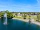 Beautiful view of a pond with a fountain, flag display, and lush green landscape in a serene setting at 842 Jolanda Cir, Venice, FL 34285