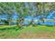 Lush green backyard featuring serene lake views and mature trees at 9022 Coachman Dr, Venice, FL 34293