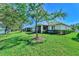 Green backyard featuring a manicured lawn and views of a lake at 9022 Coachman Dr, Venice, FL 34293