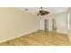 Airy bedroom features wood-look floors, ceiling fan, closet, and attached bathroom at 9022 Coachman Dr, Venice, FL 34293