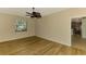 Spacious bedroom with wood-look floors, ceiling fan, and a view of the kitchen at 9022 Coachman Dr, Venice, FL 34293