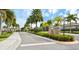 Beautiful Pennington Place community entrance with palm trees, lush landscaping, and clear signage at 9022 Coachman Dr, Venice, FL 34293