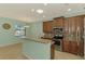 Charming kitchen showcases granite counters, backsplash, brown cabinetry, and stainless appliances at 9022 Coachman Dr, Venice, FL 34293