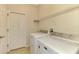 Laundry room complete with washer, dryer, storage shelves, and tiled floor at 9022 Coachman Dr, Venice, FL 34293