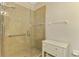 Shower features glass doors, tiled walls, and grab bars for accessibility at 9022 Coachman Dr, Venice, FL 34293