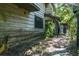 Charming exterior of the home features weathered wood siding and brick pathway to the front door at 9625 Erie Rd, Parrish, FL 34219