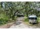 Home with a silver Airstream parked nearby and covered in mature, shady landscaping at 9625 Erie Rd, Parrish, FL 34219