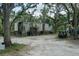 Exterior shot of the property with a metal trailer and other vehicles on the grounds at 9625 Erie Rd, Parrish, FL 34219