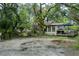 Home with a gravel driveway and mature landscaping featuring an expansive covered porch at 9625 Erie Rd, Parrish, FL 34219