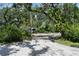 Gravel driveway leading to a parking area with mature landscaping framing the residence at 9625 Erie Rd, Parrish, FL 34219