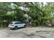 Exterior shot of the home with mature landscaping, driveway and parked car at 9625 Erie Rd, Parrish, FL 34219