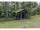 Overgrown outbuilding offers additional storage on a shaded, heavily vegetated lot at 9625 Erie Rd, Parrish, FL 34219