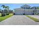 Two-story townhome with a two-car garage, paved driveway, green grass, and an American flag at 1017 Tidewater Shores Loop # 1017, Bradenton, FL 34208