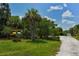 A wooden rack on the community grounds houses 2 kayaks with a tree lined street behind them on a beautiful sunny day at 1017 Tidewater Shores Loop # 1017, Bradenton, FL 34208