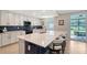 Modern kitchen with a large island, white cabinets, blue subway tile backsplash, and stainless steel appliances at 1017 Tidewater Shores Loop # 1017, Bradenton, FL 34208