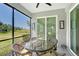 Screened lanai featuring a table, providing an unobstructed view of the golf course and scenic landscape at 1017 Tidewater Shores Loop # 1017, Bradenton, FL 34208