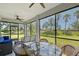 Screened-in lanai with comfortable seating and views of the well-manicured backyard and palm trees at 1017 Tidewater Shores Loop # 1017, Bradenton, FL 34208