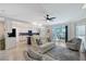Bright living room featuring neutral decor, tile flooring, modern ceiling fan, and an open flow into the kitchen and outdoor patio at 1017 Tidewater Shores Loop # 1017, Bradenton, FL 34208