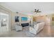 Open-concept living room with light walls, tile floors, ceiling fan, and access to bedrooms and a screened lanai at 1017 Tidewater Shores Loop # 1017, Bradenton, FL 34208