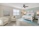 Serene main bedroom with a white bed, ceiling fan, and large windows providing plenty of natural light at 1017 Tidewater Shores Loop # 1017, Bradenton, FL 34208