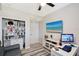 Office featuring a desk, leather couch, bookcase and beach-themed TV at 1017 Tidewater Shores Loop # 1017, Bradenton, FL 34208