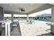 Community pool area boasts a covered seating area with a bar, lounge chairs, and views of the water at 1017 Tidewater Shores Loop # 1017, Bradenton, FL 34208