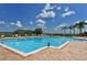 Large community pool with lounge chairs, palm trees, and clear blue skies at 1017 Tidewater Shores Loop # 1017, Bradenton, FL 34208