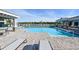 Inviting community pool area with lounge chairs, cabanas, and beautiful scenery at 1017 Tidewater Shores Loop # 1017, Bradenton, FL 34208