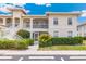 Inviting condo exterior with manicured landscaping, tile roof and staircase leading to second floor at 10202 L Pavia Blvd # 10202, Venice, FL 34292