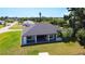 An aerial view showcases a home's spacious backyard with lush green grass and a covered patio at 10588 Kidron Ave, Englewood, FL 34224